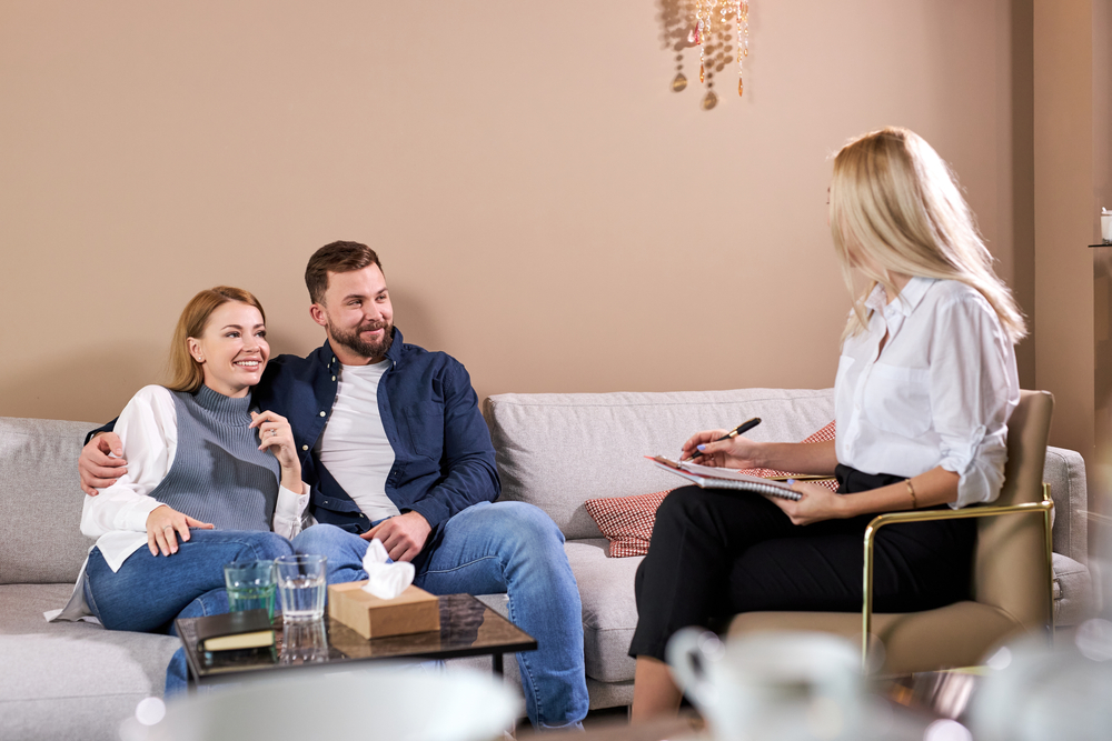 Nice pleasant caucasian couple visiting professional psychologist and having psychological session in office
